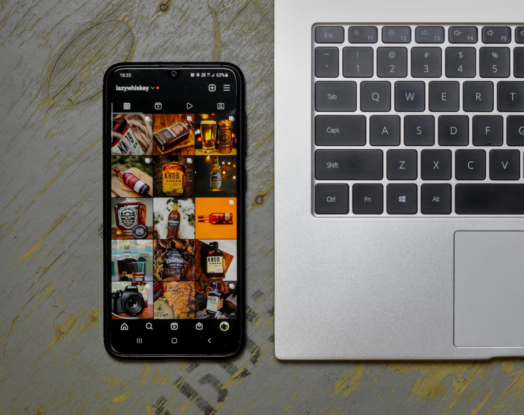 macbook and a phone with instagram feed on it