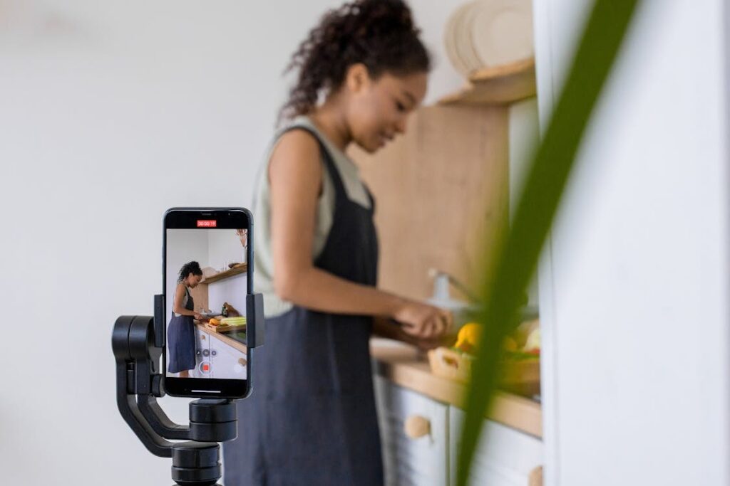 Person recording a cooking video on a smartphone for social media content creation