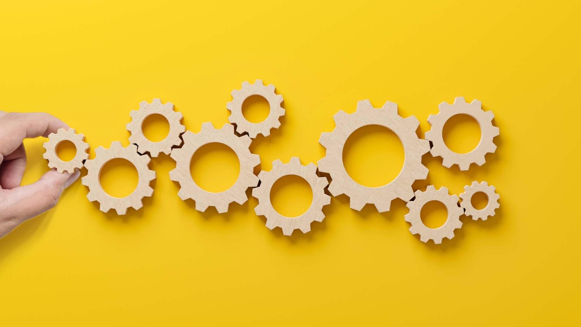 Wooden gears on a yellow background