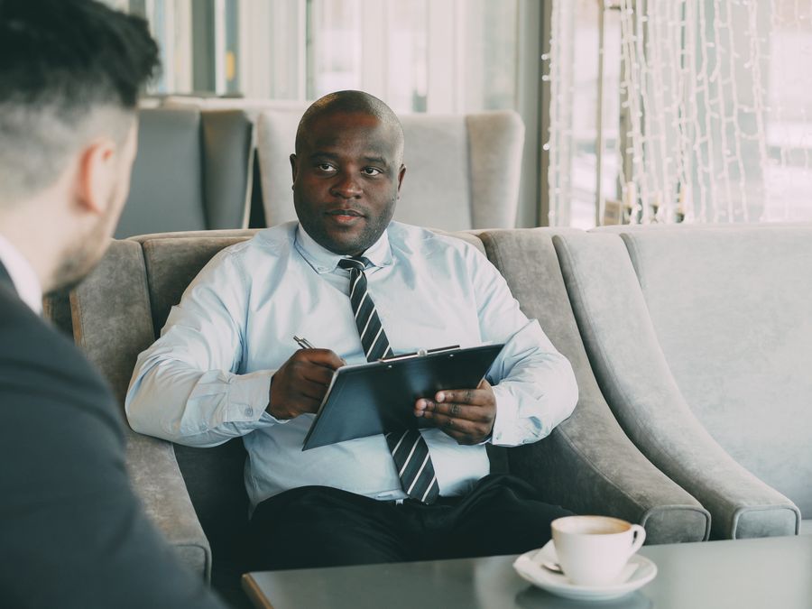 Two businessmen having a meeting in a modern cafe, engaged in discussion.