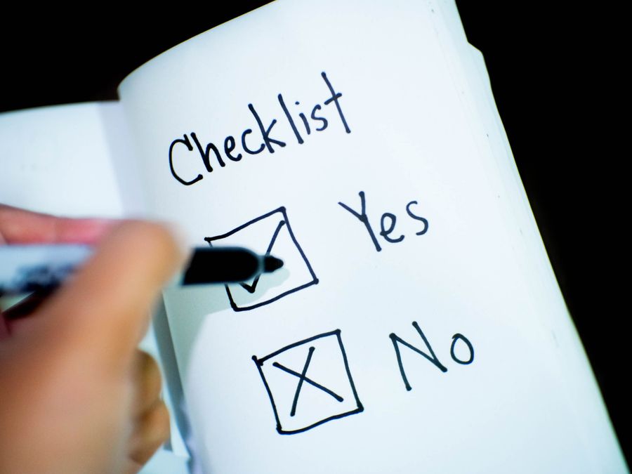 A notebook featuring a checklist with a marked 'Yes' box, captured in a close-up shot.
