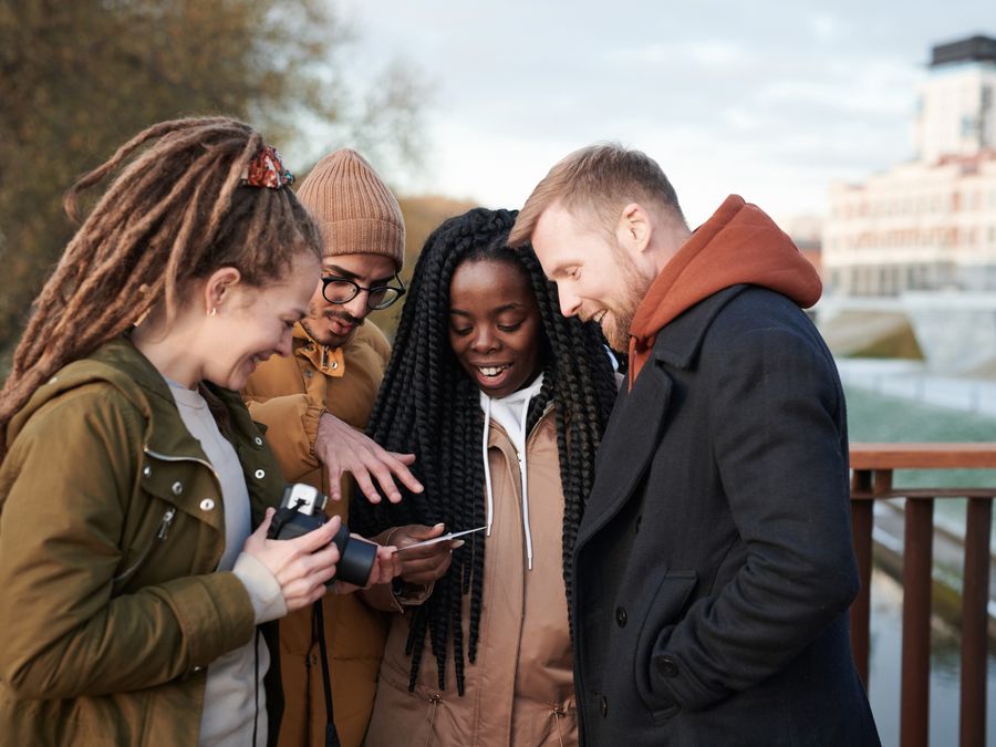 Friends sharing a moment outdoors in winter attire, smiling and happy.