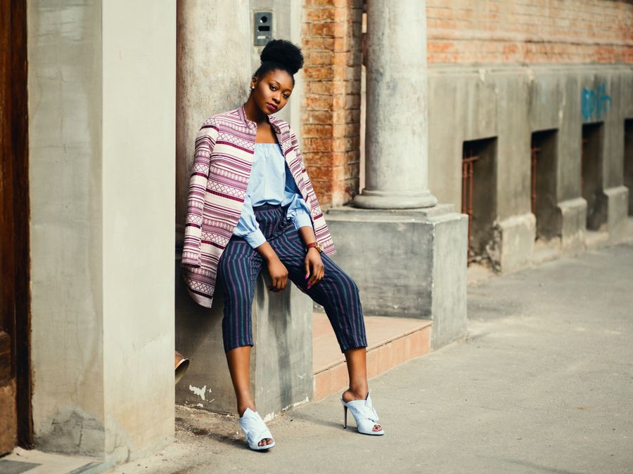 Fashionable woman in an urban setting wearing a chic outfit and posing confidently.