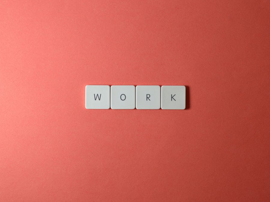 Minimalist image featuring the word 'work' with keyboard keys on a coral background. Perfect for workplace or business themes.