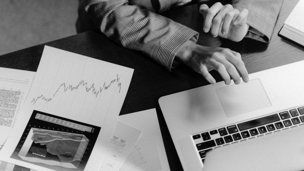 Focused workspace with business charts and laptop for financial analysis.