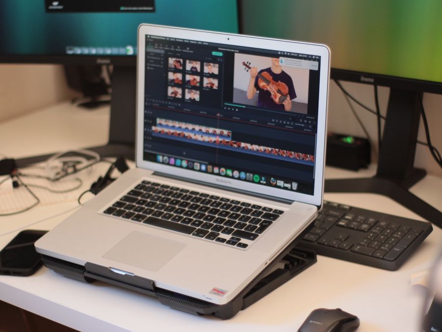 A workspace featuring a laptop editing a video, showcasing modern technology and video editing software.
