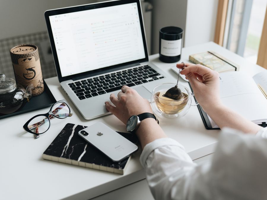 A cozy home office scene with a laptop, tea, and workspace essentials.