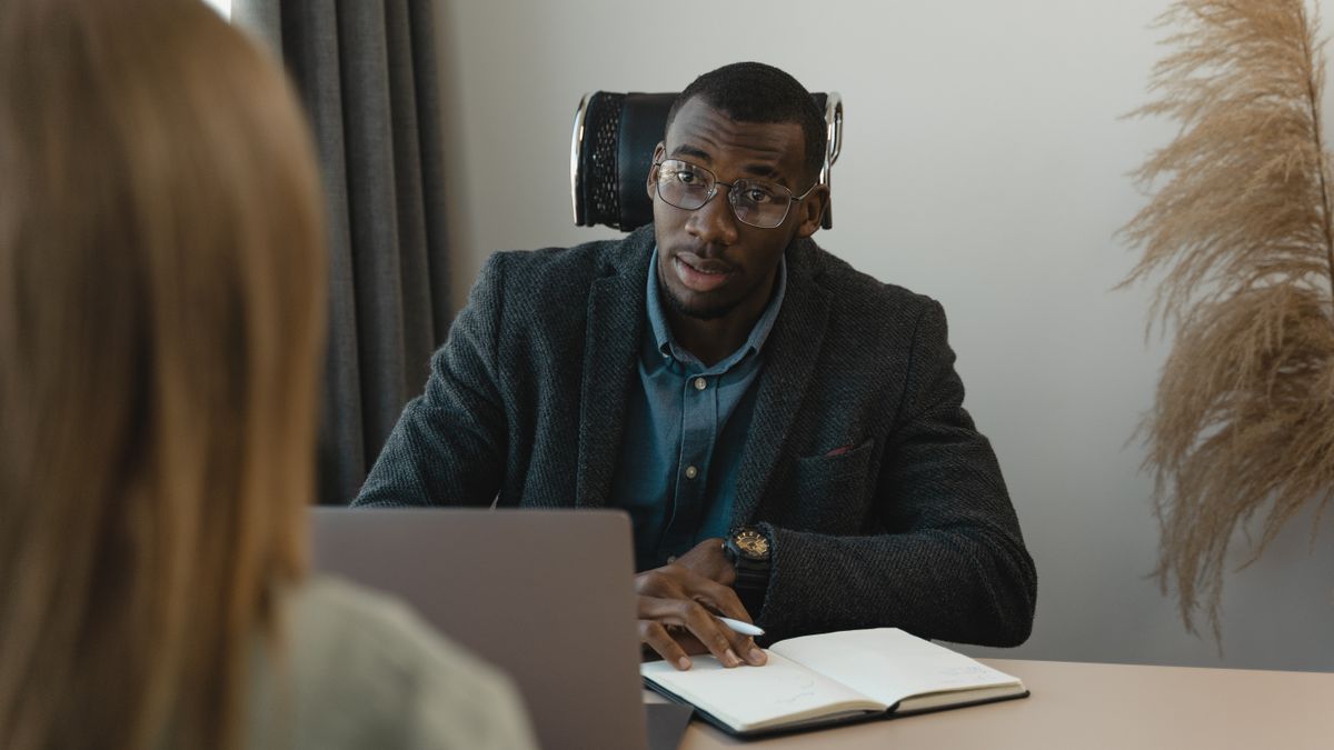 Businessman conducting a formal interview in a modern office environment.
