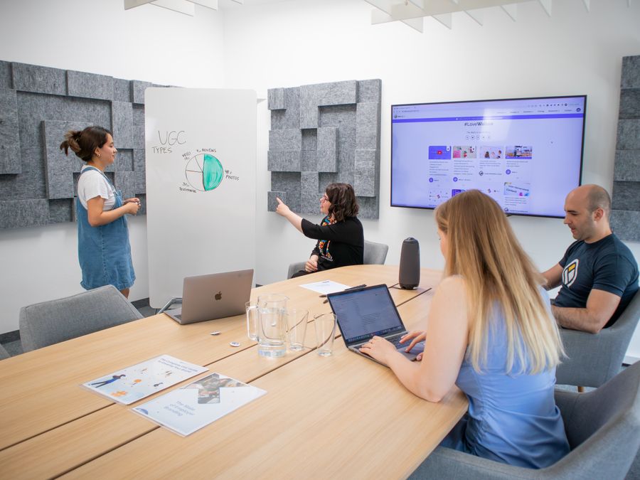 A group of professionals engaged in a team meeting with a presentation in a modern office setting.