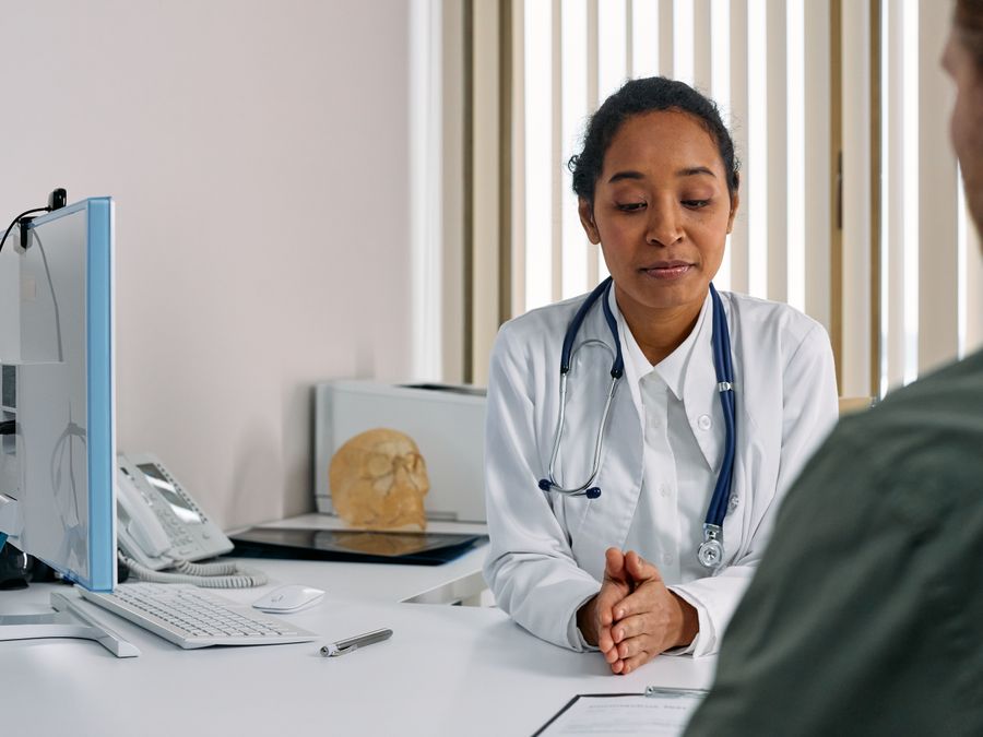 A female doctor consulting a patient in a modern medical office setting.
