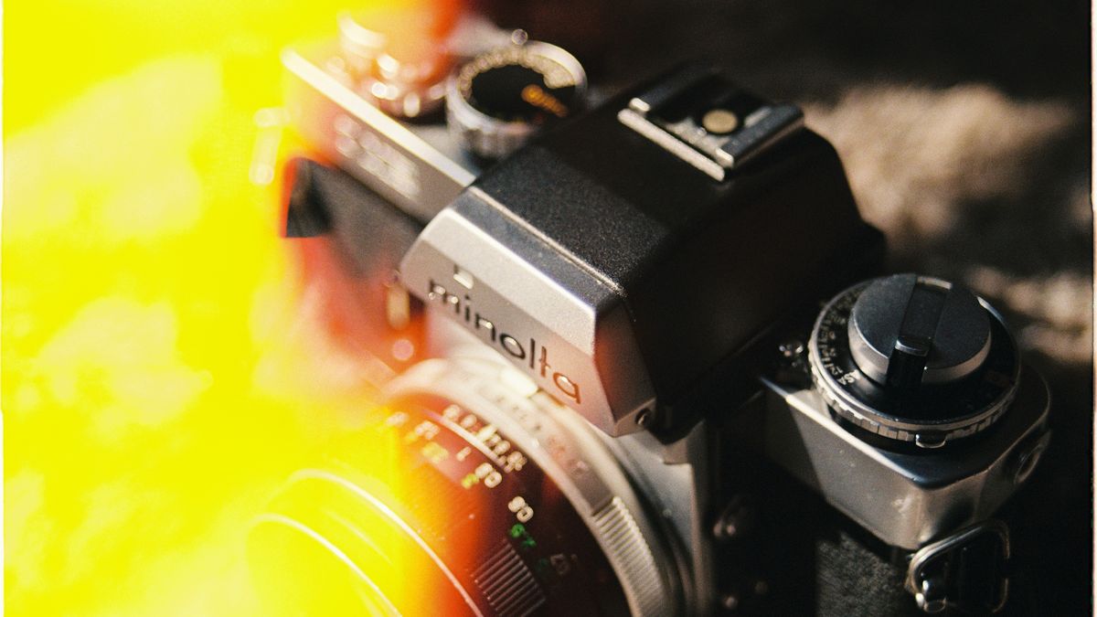 Close-up of a vintage Minolta film camera with artistic light leak effect, evoking nostalgia and retro charm.