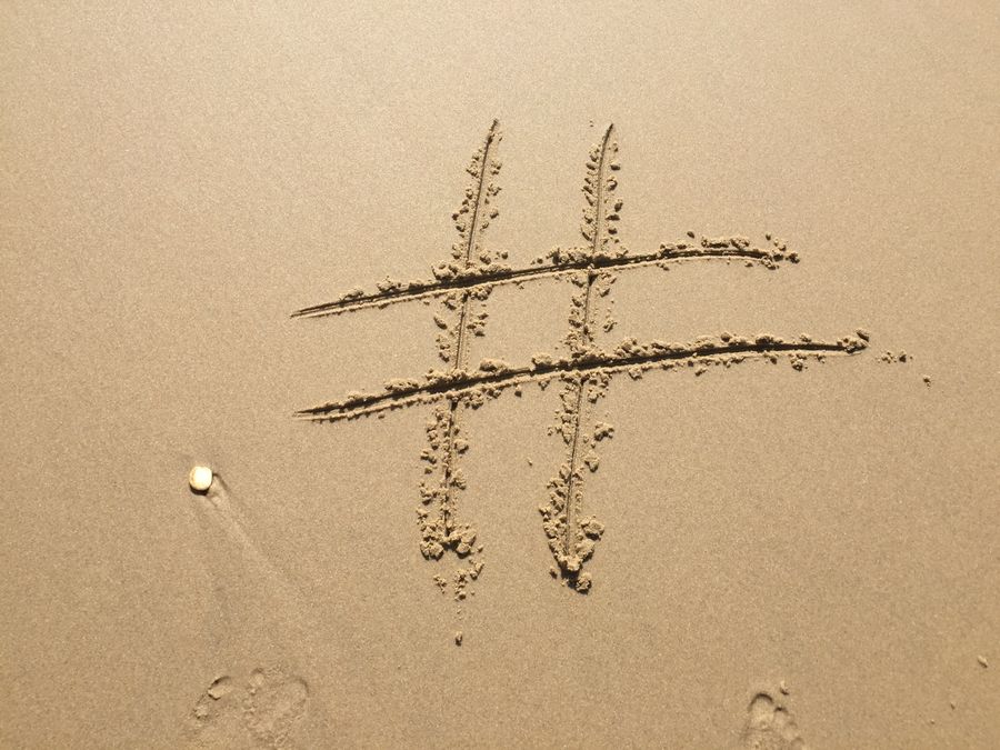 A hashtag symbol drawn on sandy beach in Vensac, France, ideal for social media themes.