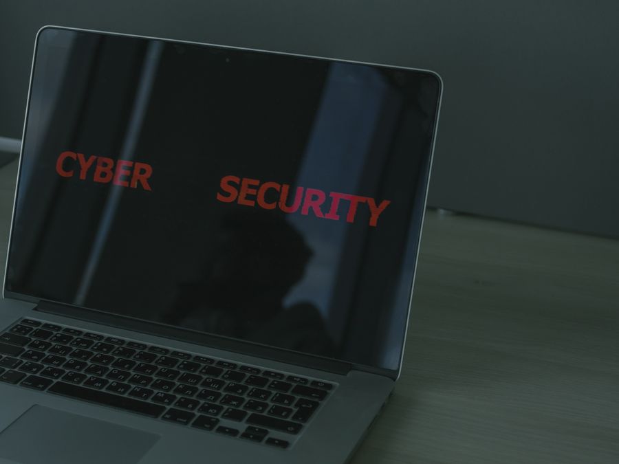 Close-up of a laptop displaying cybersecurity text, emphasizing digital security themes.