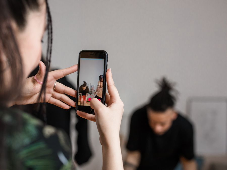 Close-up of a person recording a video with a smartphone indoors, focusing on creative content creation.