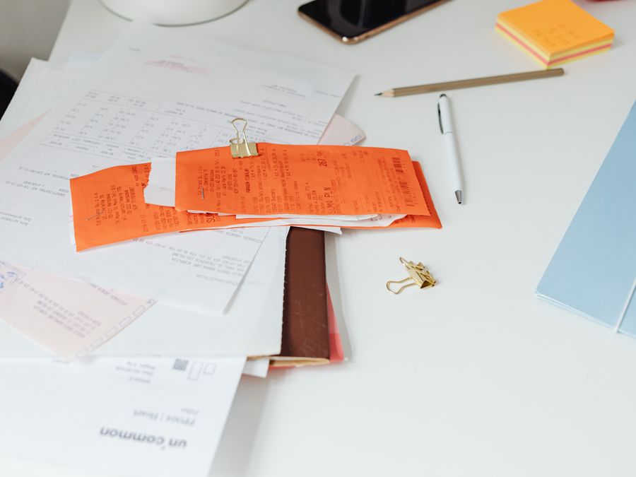 Close-up of a tidy desk with receipts, documents, and office stationery for business organization.