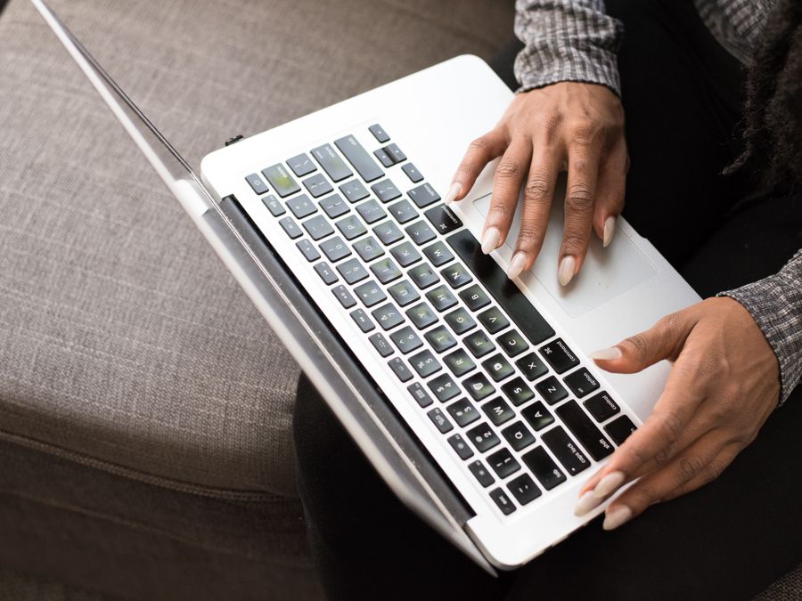 A woman typing on a laptop keyboard, focused on productivity and technology.