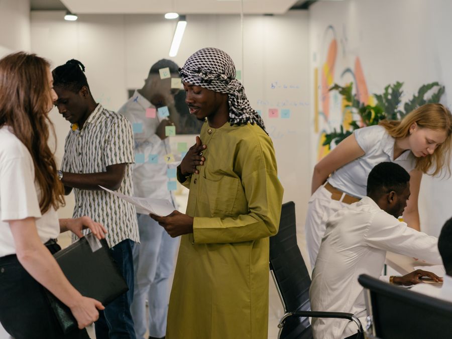 Diverse team engaged in discussion and collaboration in a modern office setting, showcasing teamwork and diversity.