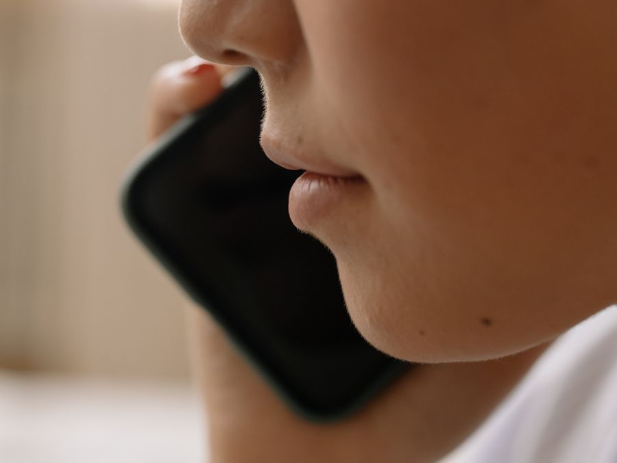 A close-up of someone talking on a smartphone, focusing on the lower face.