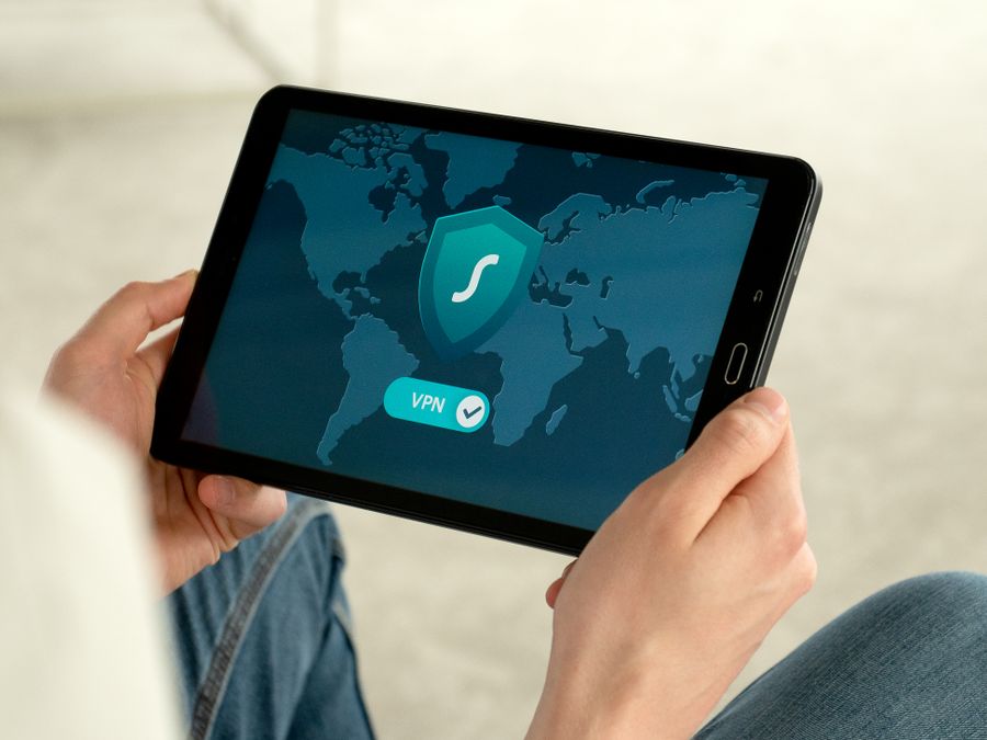 Person holding tablet with VPN connection screen for secure internet browsing.