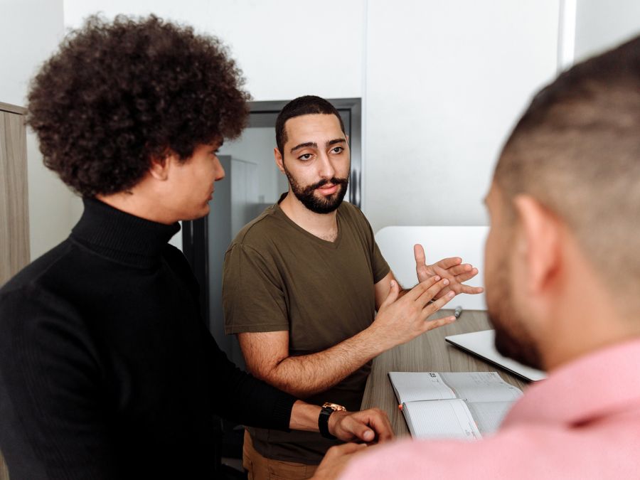 Group of colleagues having a thoughtful discussion in a modern office setting.