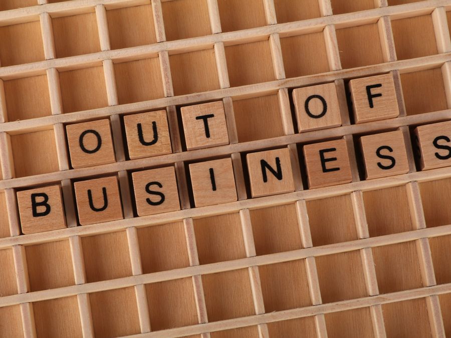 Wooden blocks spelling 'Out of Business', conveying closure or financial difficulties.