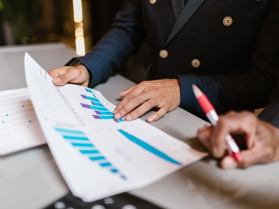 Close-up of professionals reviewing financial graphs at a business meeting.