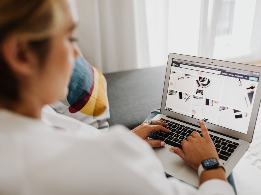 Person using laptop in a cozy home setting, focusing on digital content browsing.