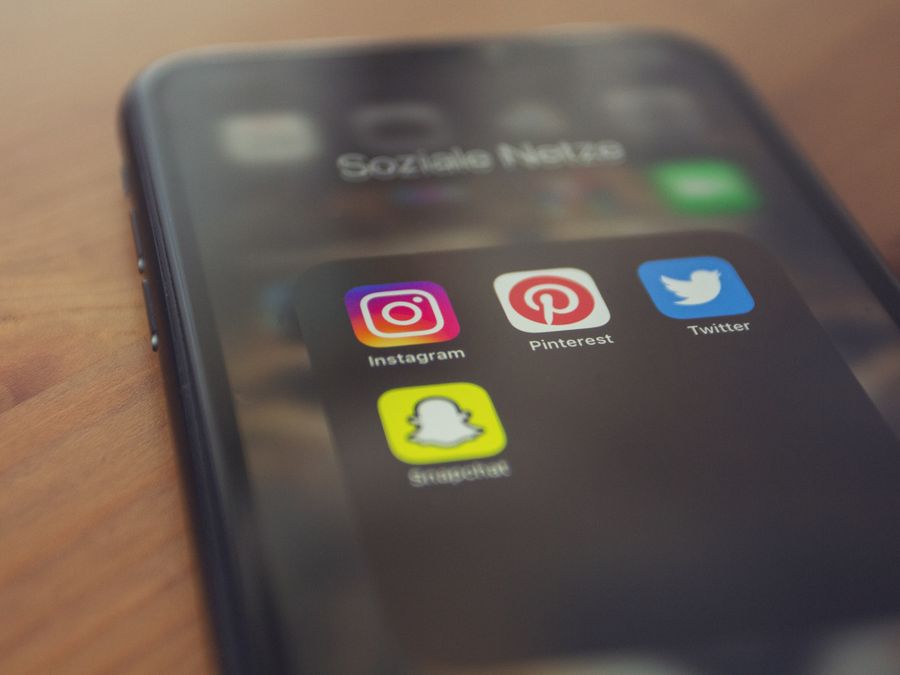 Smartphone displaying popular social media apps like Instagram, Pinterest, Twitter, and Snapchat.