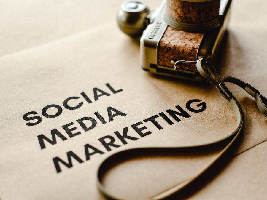 Close-up of a camera placed on brown paper with 'Social Media Marketing' text, emphasizing digital marketing themes.