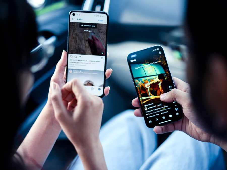 A couple engaging with social media on smartphones indoors, illustrating modern digital connectivity.