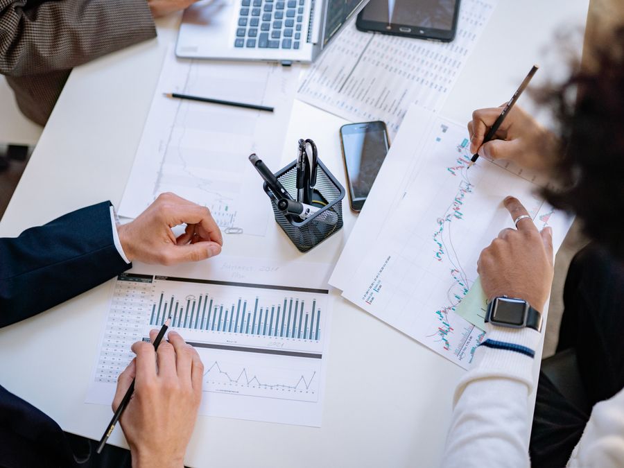 Business team analyzing financial charts and graphs during a collaborative meeting.