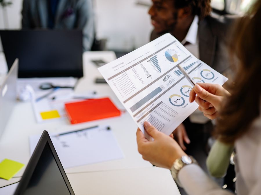 Professionals reviewing business charts and documents in a team meeting.