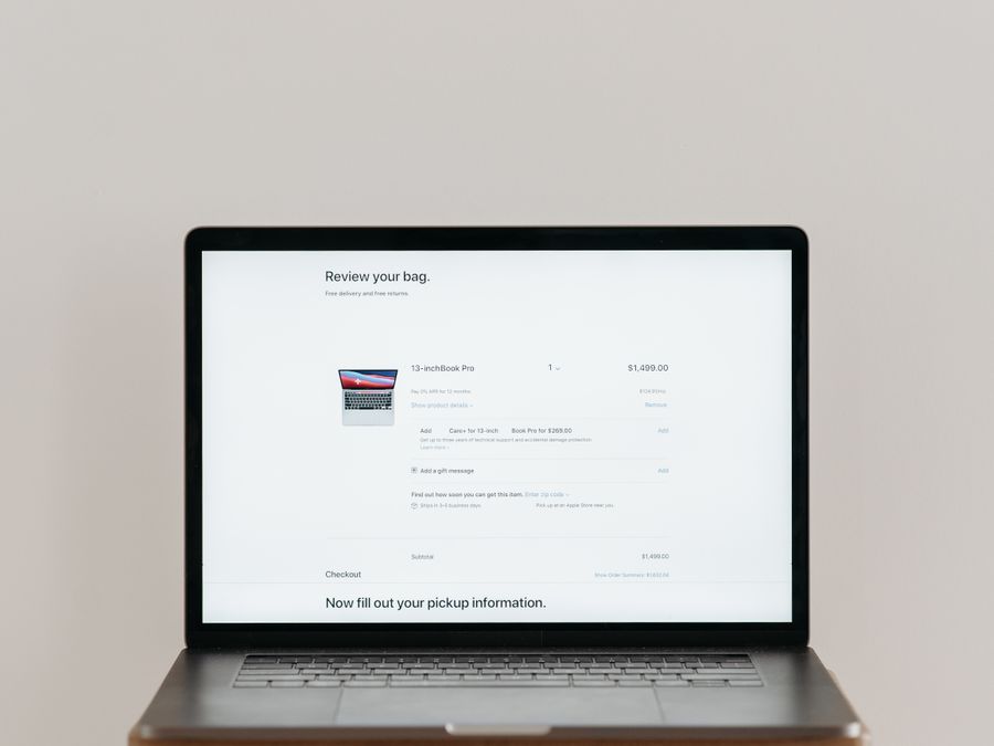 Minimalist laptop showing an online checkout screen on a white background, ideal for tech context.