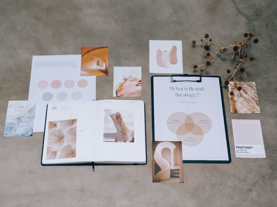 A flat lay of branding elements with color palettes and strategic planning documents on a concrete surface.