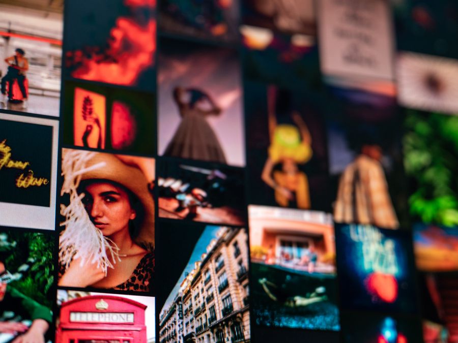 Various images of elegant people and building facade near creative titles hanging on wall in apartment as symbol of memorable moments