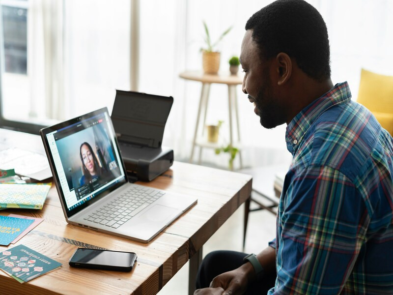 Person participating in a video call on a laptop from home